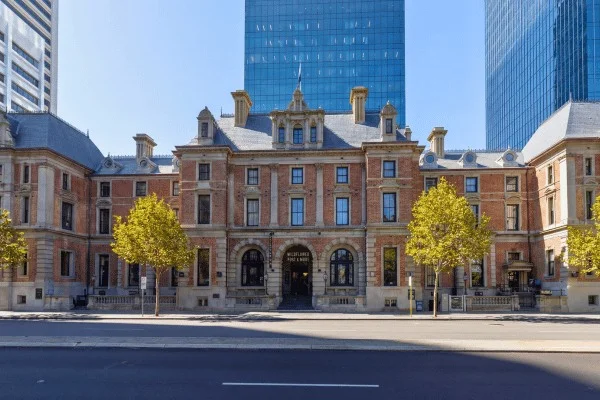 Une façade civique ancienne se dresse dans l’échelle bien plus vaste du Perth d’aujourd’hui.